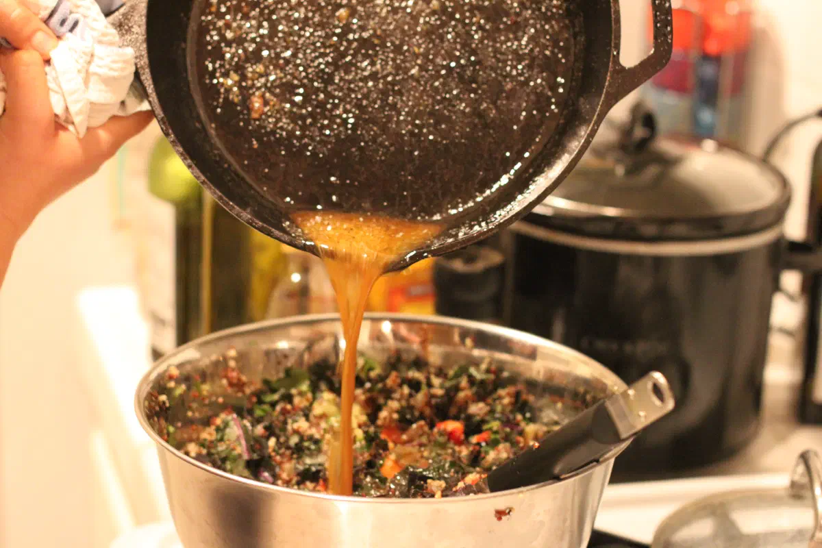 Pouring the warm vinaigrette on the salad